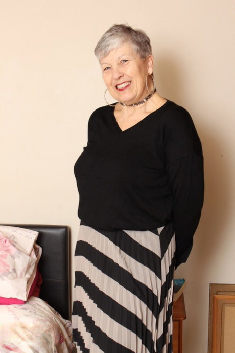 Mature British lady Savana undresses on bed and fools around naked