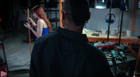 Redhead girl Violet Monroe is suspended by ropes in a dungeon setting