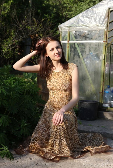 18 year old brunette Emma gets bare naked while gardening by a greenhouse