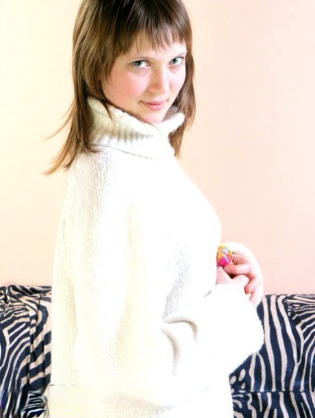 Teen amateur Anabell licks a sucker while taking off her sweater to pose nude
