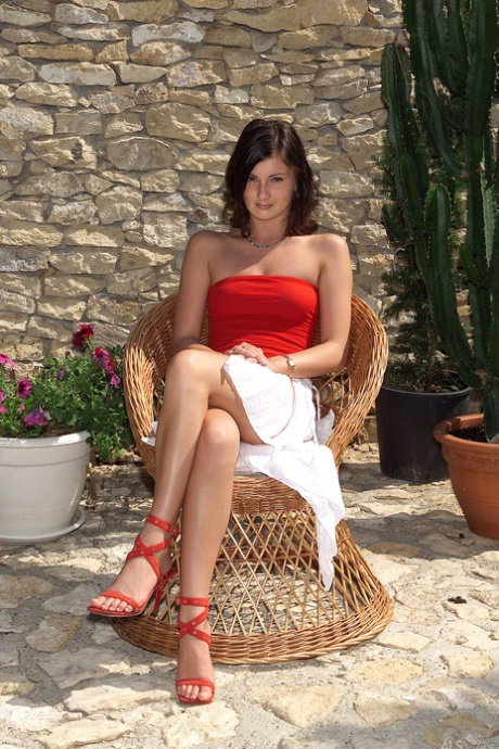Amateur model strips to her red heels before masturbating on a chair outdoors