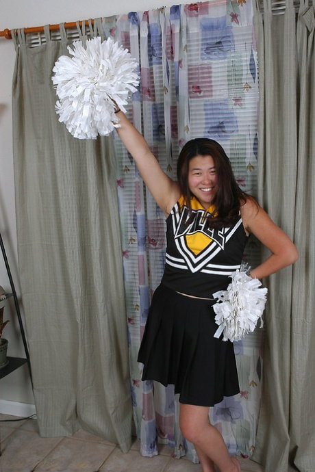 Asian amateur strips off cheerleader uniform before spreading pussy lips