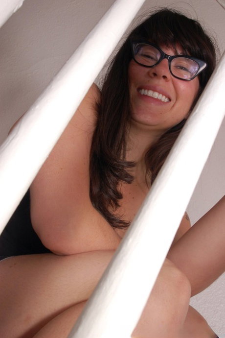 Busty amateur Cleo exposes her big boobs & her hairy muff on the stairs