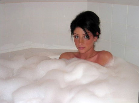 Brunette teen Carma takes a bubble bath in a teasing fashion