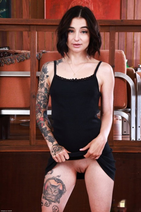 Tattooed brunette Stevie Moon parts her pussy lips in a closeup shot