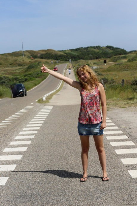 Slutty redhead hitchhiker Nisha poses while completely naked outdoors