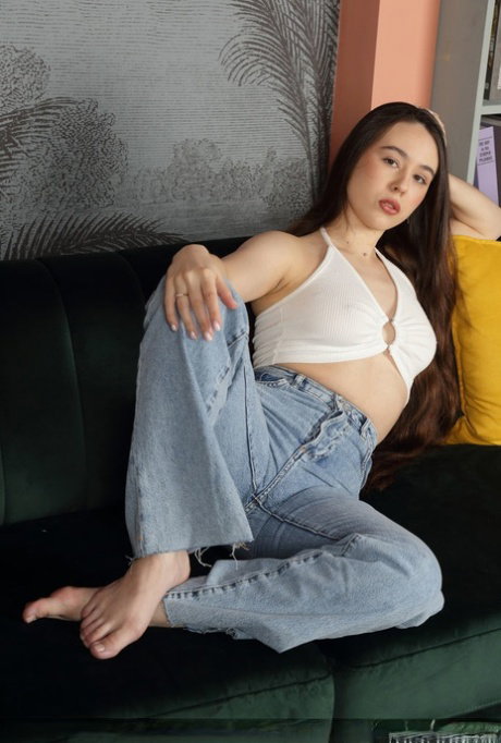 Beautiful teen Emily Eliot displays her long hair while getting totally naked