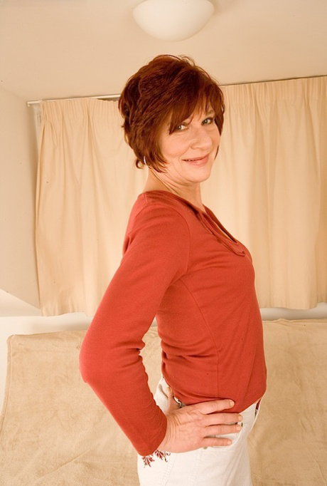 Sassy redhead mature lady undressing and spreading her legs
