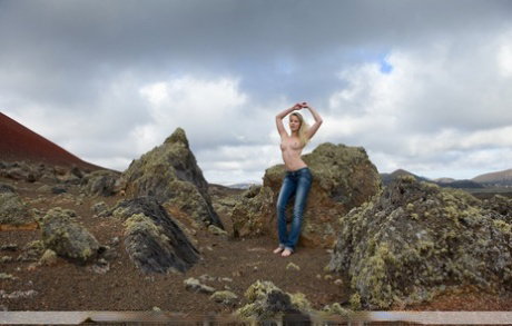 Long legged blonde Belinda models totally naked in a barren location