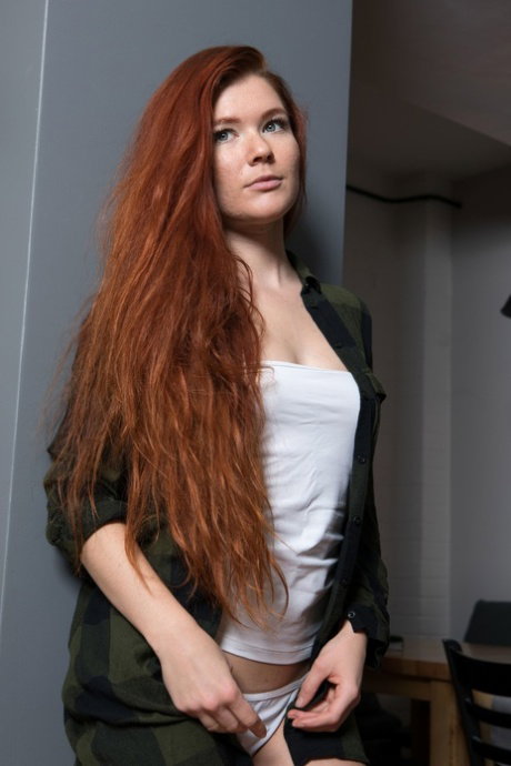 Long haired redhead unveils her cute boobs and shaved pussy in a solo