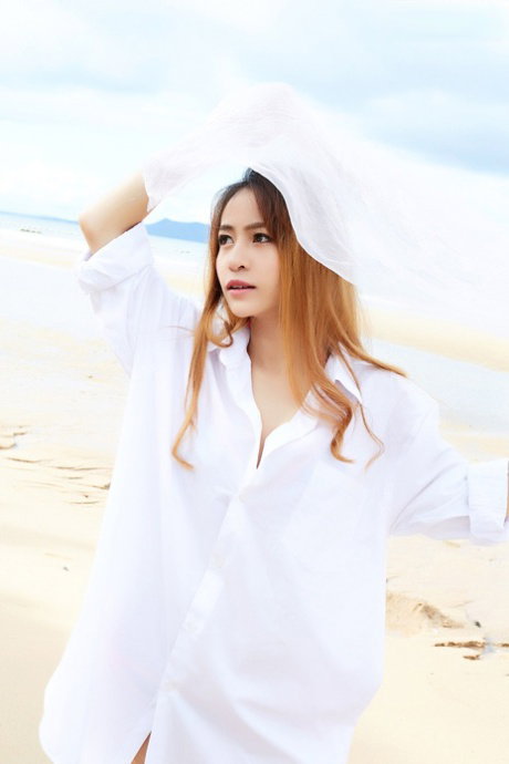 Redheaded Asian girl Eileen models a bikini at the beach before getting naked