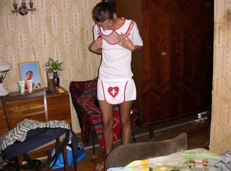 Amateur chick Dasi West poses non nude in a naughty nurse outfit on a bed