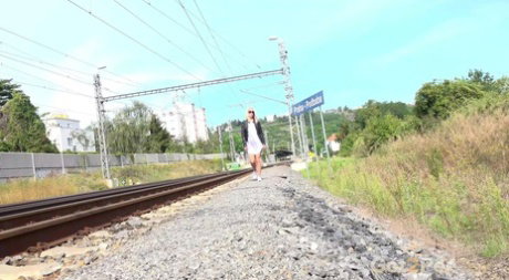 Blonde chick Debora shows her shaved pussy while peeing beside railway tracks