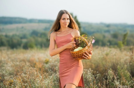 Girl next door Riana Jolie pets her nude pussy on a blanket in a field