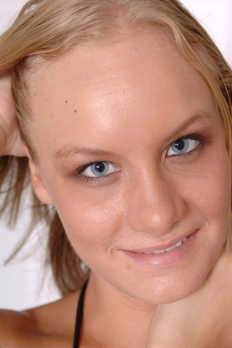 Skinny blonde girl slips off denim jeans before showing her snatch
