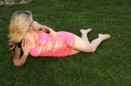 Dirty blonde amateur Lily Xo poses against fence in revealing pink dress