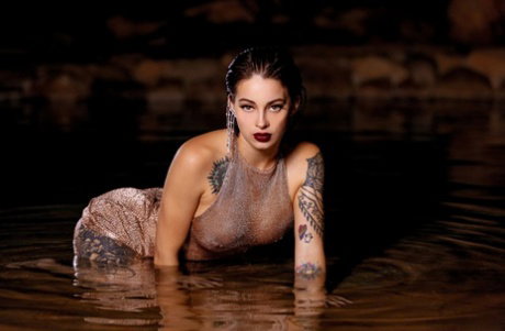 Inked honey Maddy May reveals her tits and hot ass in shallow water