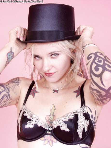 Tattooed blonde Voltaire Blue doffs a top hat while getting naked in heels