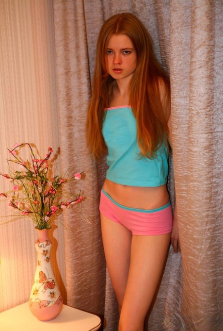 18-year-old redhead Avril A goes topless in a provocative manner
