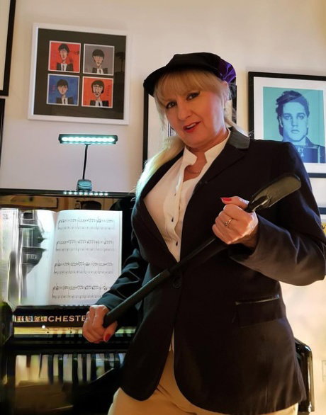 Older blonde woman pulls down riding pants to show her snatch in black boots