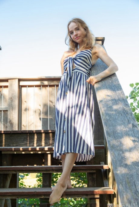 Beautiful blonde teen Rinna Ly slips off her dress to go nude on deck stairs