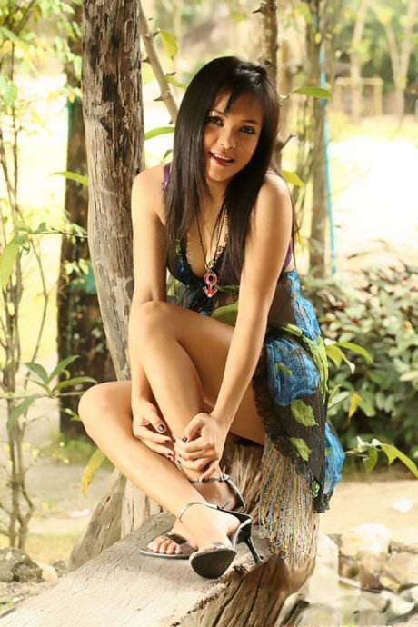 Pretty Thai girl Rose Pathra gets naked in ankle strap heels against a tree