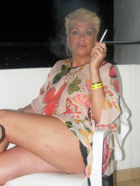 Middle-aged blonde Dimonty smokes while getting completely naked