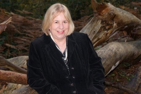 Mature British woman Speedy Bee gets naked in a forest while wearing boots