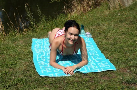 Brunette amateur has her hairless pussy fisted by a blonde lesbian near water