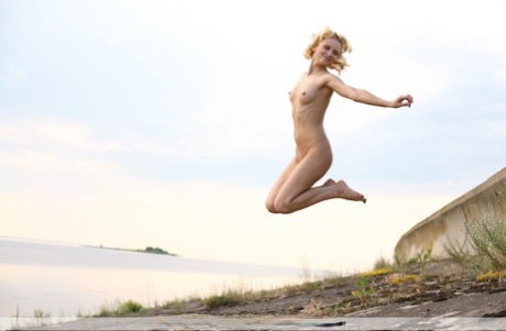 Totally naked teen Odele hits upon great poses during waterside action