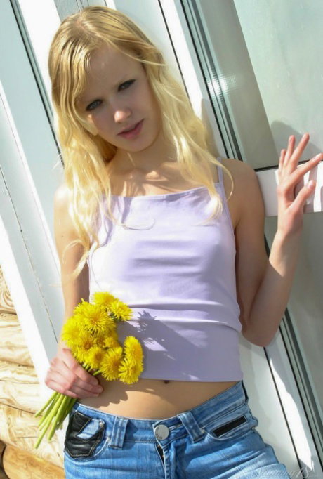 18-year-old blonde Yana F frees her thin body of clothing out back of her home
