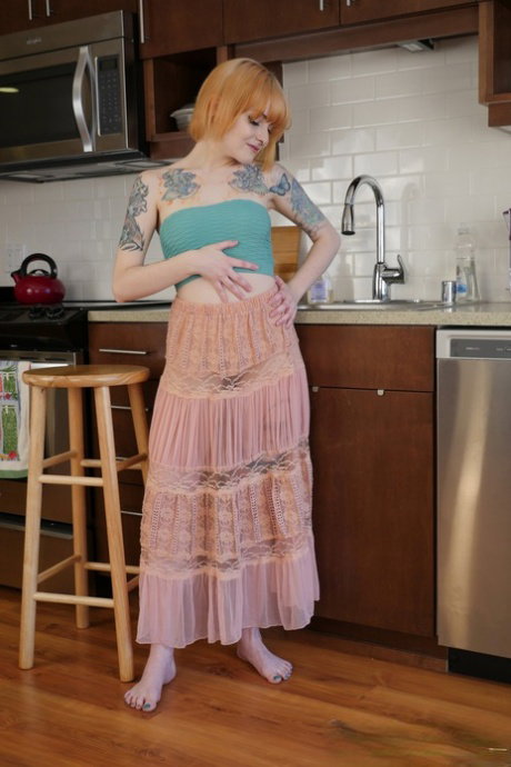 Alt model with a tattooed body Danae Kelley fingering her pussy in the kitchen