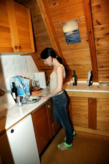 Lustful brunette teen stripping and masturbating her pussy in the kitchen