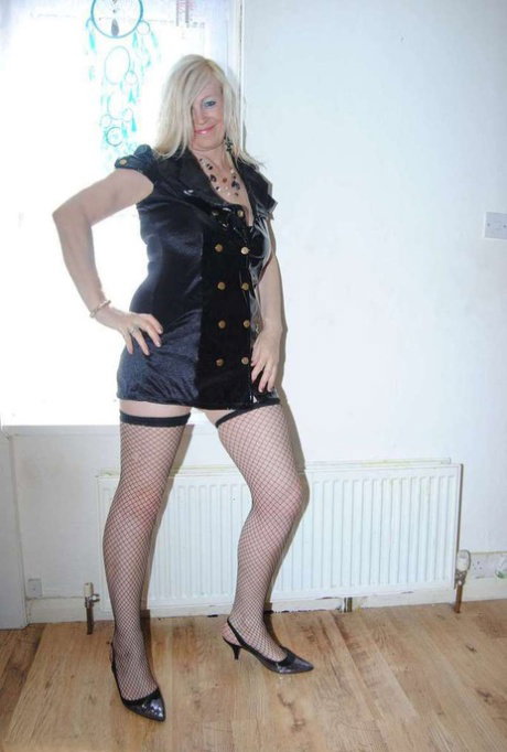 Mature blonde woman Dimonty frees her tits and twat from a short latex dress