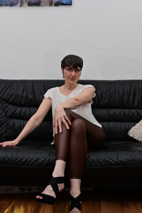 Amateur model by the name of Hot MILF doffs leather pants to get naked