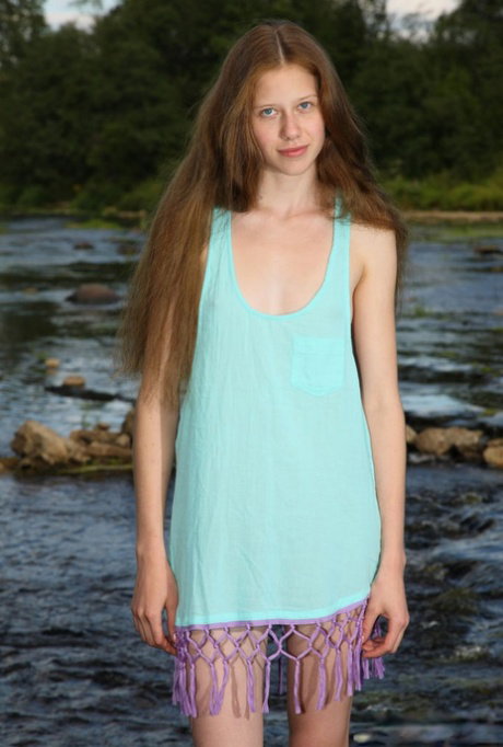 Barely legal girl with long red hair gets totally naked in a brook