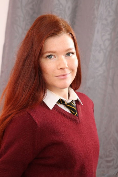 Redhead teen Mia S doffs her school uniform and poses topless in her dorm room