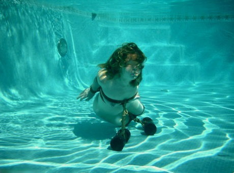 Curvaceous American MILF posing bound at the bottom of the pool