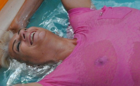 Mature blonde Dimonty takes off her wet T-shirt while in a wading pool
