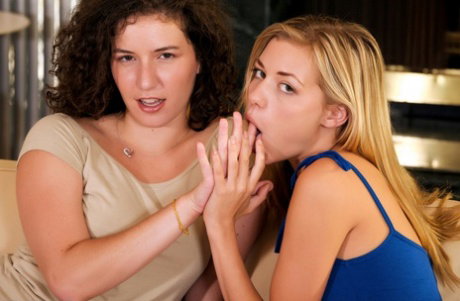 Lesbian girls finger each others pussy while having sex on a couch