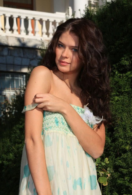 Beautiful teen Liza J gets completely naked while on a garden path