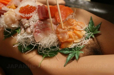 Sweet Asian babe Ramu Nagatsuki gets toyed while covered with sushi on a table