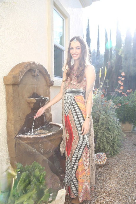 Bohemian brunette beauty Tali Dova poses in her hippy gown in the garden