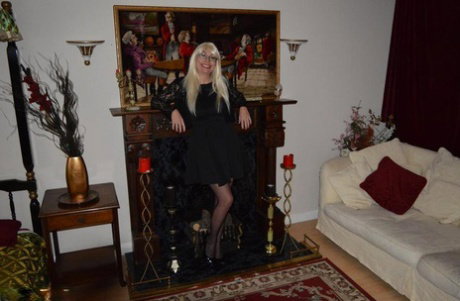 Mature blonde Barby Slut gets naked on a sofa in garters and nylons
