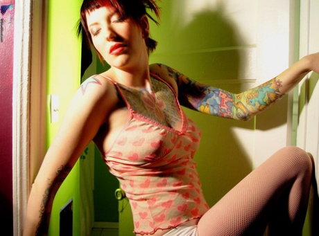Tattooed redhead Erica uncovers her great tits during solo action