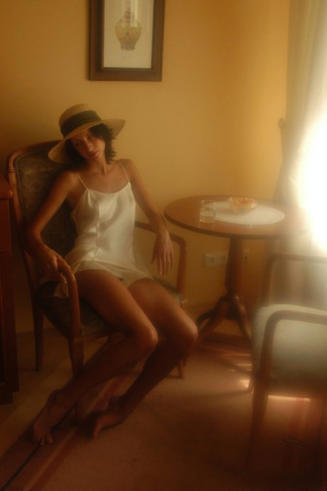 Slim teen reveals her small tits while wearing a straw hat and white lingerie