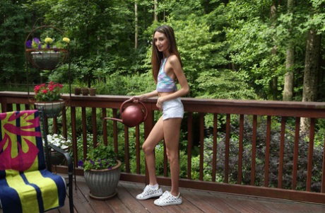 Leggy teen Natalia Nix pleasures her shaved twat on a deck in sneakers