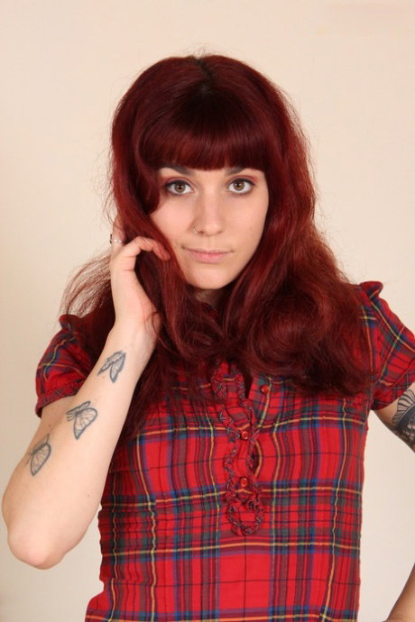 Tattooed redhead Lauretta displays her flexible toes after removing shoes