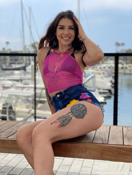 Tattooed girl Brenna Mckenna models swimwear at a marina before a POV blowjob