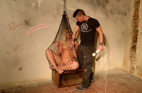 Naked blonde Sandy gets masturbated with a vibrator while trapped in a net